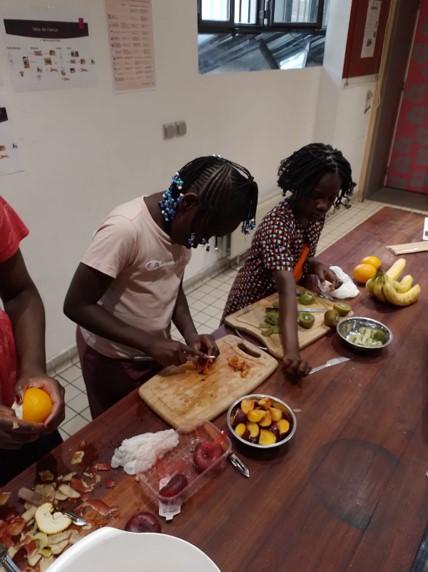 Enfants qui coupent des fruits pendant l'atelier de cuisine