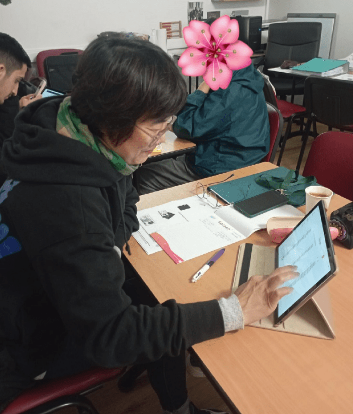 Une étudiante asiatique utilisant une tablette digitale lors de l'atelier numérique dans le cadre du parcours linguistique à visée professionnelle