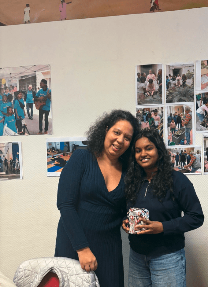 Mme Chau, la professeure et 1 élève souriante de l'atelier de conversation en français de l'association Axes Pluriels qui s'échangent des cadeaux de Noël pour décembre 2025