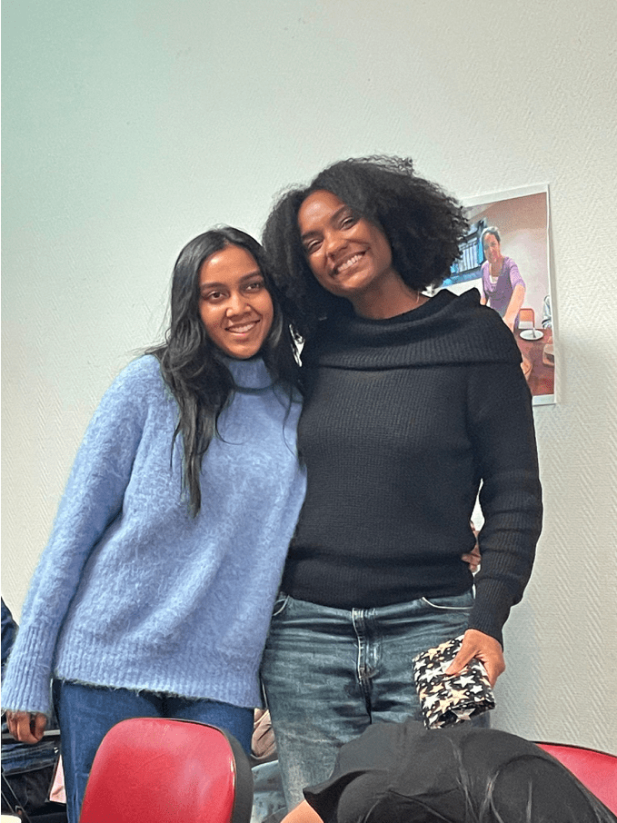 2 élèves souriants de l'atelier de conversation en français de l'association Axes Pluriels qui s'échangent des cadeaux de Noël pour décembre 2025