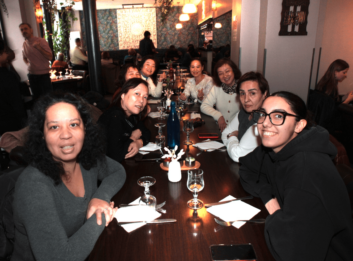 Photo de groupe à table au début du repas de fin d'année 2025 de l'association Axes Pluriels
