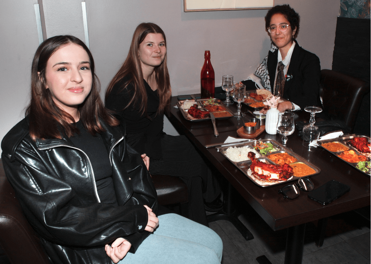 Photo de groupe des bénévoles et services civiques assis à table lors du repas de fin d'année 2025 de l'association Axes Pluriels