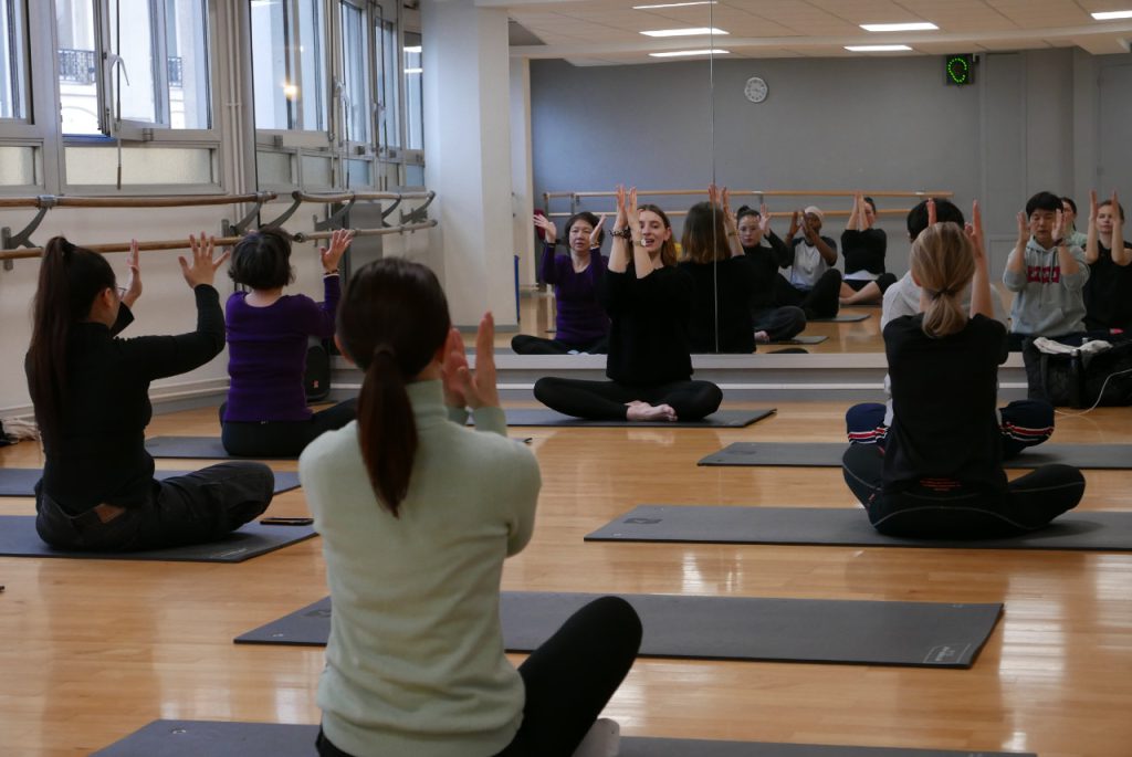 groupe de femmes qui pratiquent assises le pilates