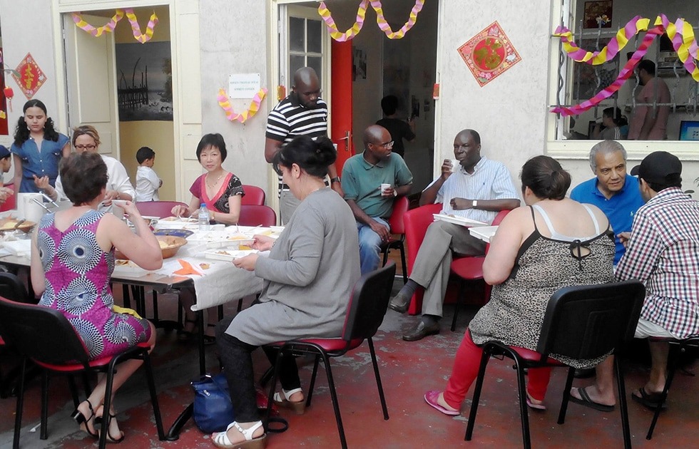 Repas avec les familles du quartier et tous les intervenants d'Axes pluriels dans la cour de l'immeuble devant l'entrée de l'association
