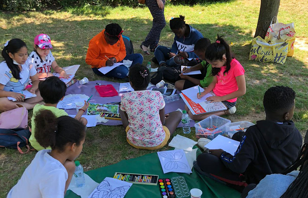 Enfants usagers dessinent sur l'herbe