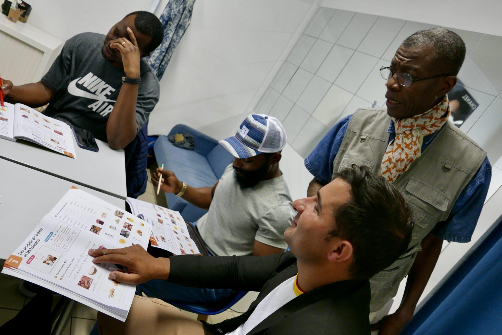 Trois élèves migrants pendant le cours de français
