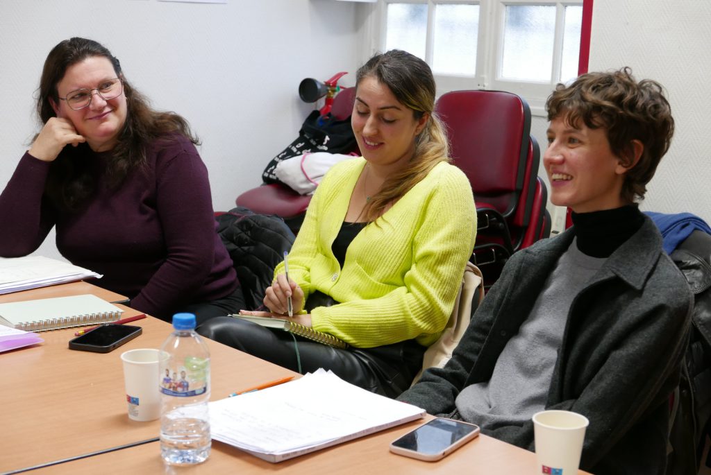 trois migrantes qui apprennent le français dans une salle de cours