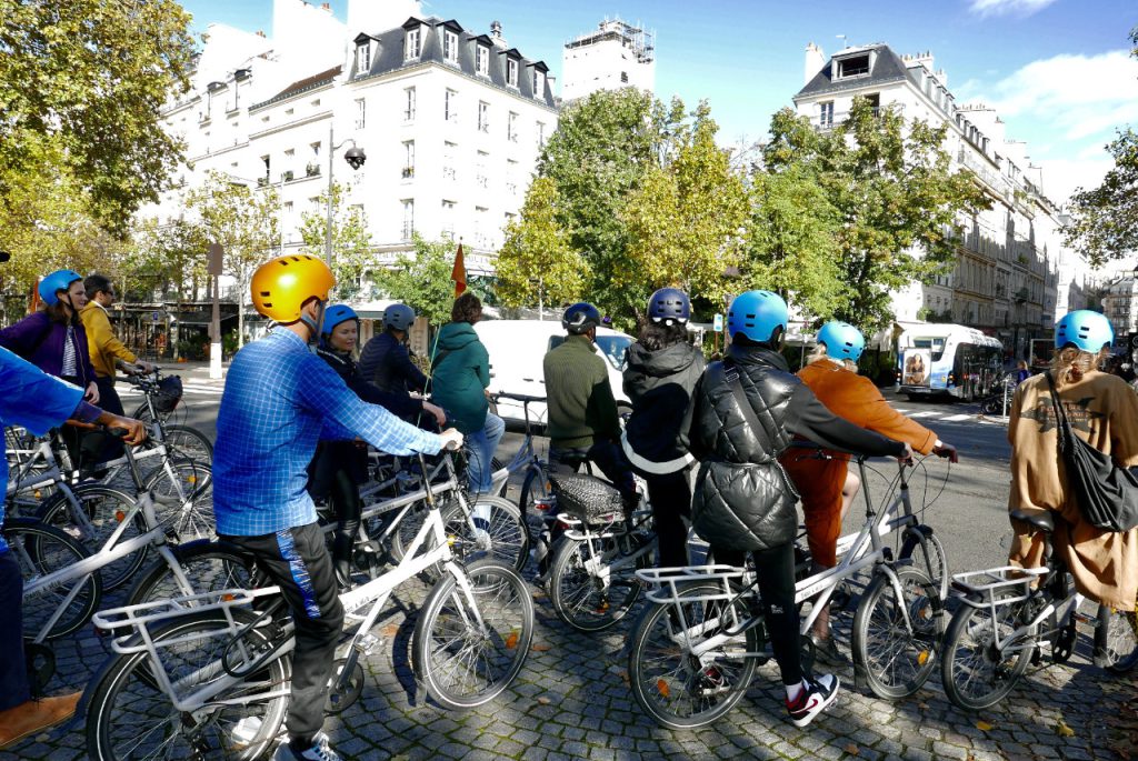 Groupe de migrants à vélo sur la route vu de côté pendant la balade à vélo dans Paris