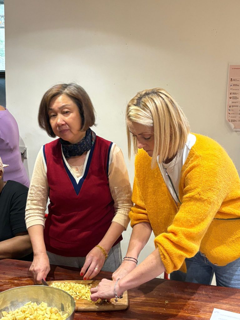 deux femmes de nationnalités différentes qui cuisinent un plat ensemble pendant l'atelier cuisine