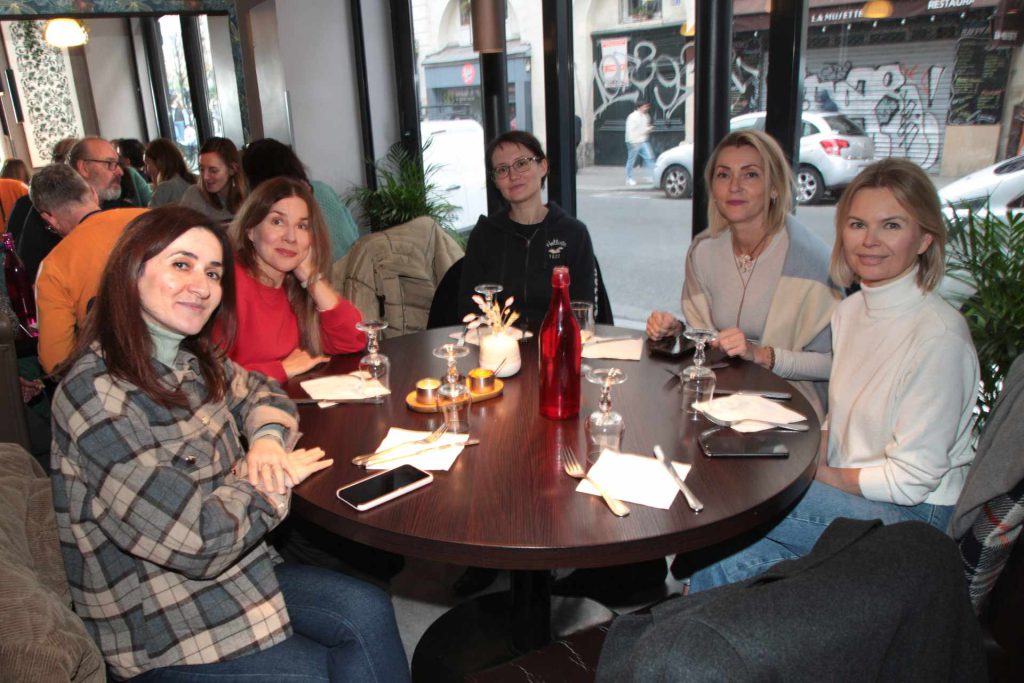 Groupe de femmes usagères de l'association Axes pluriels à table pendant le repas de fin d'année 2025 organisé par l'association