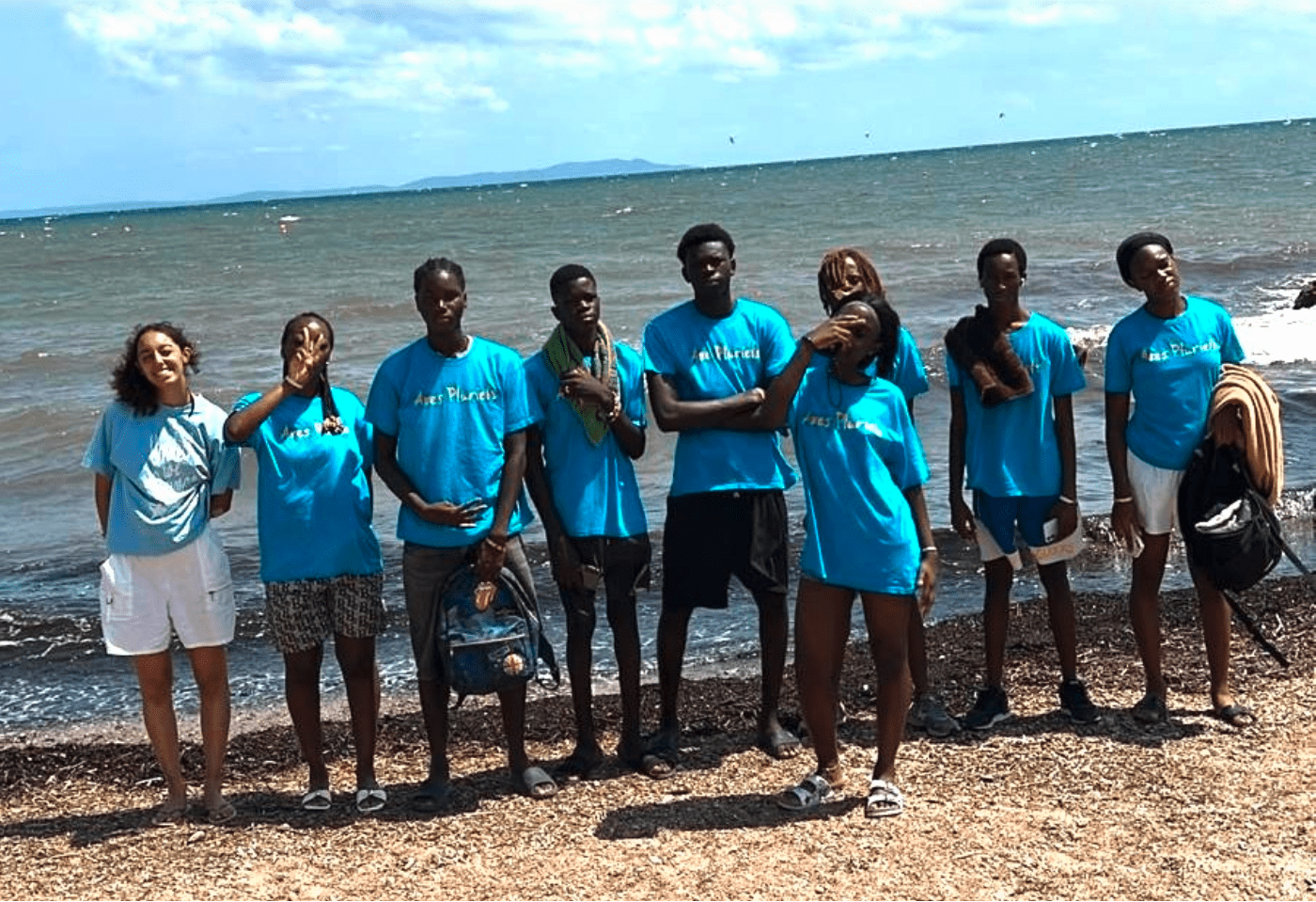 Groupe de jeunes usagers et leur animatrice de l'association portant le t-shirt bleu turquoise Axes pluriels sur la plage de Hyères